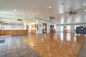 Miscellaneous room with a ceiling fan, recessed lighting, vaulted ceiling, light tile patterned floors, and a textured ceiling