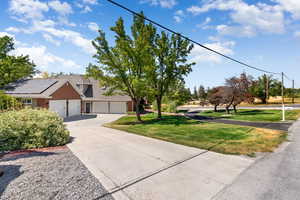 View of front facade featuring concrete driveway, a front lawn, a garage, and brick siding
