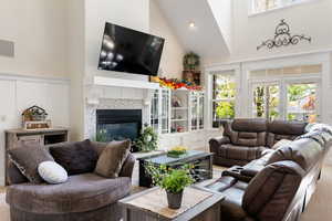 Living area with a towering ceiling, carpet, a fireplace, and recessed lighting