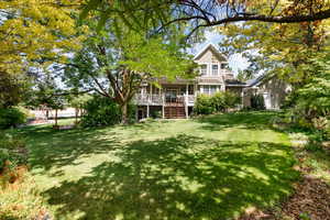Rear view of property featuring a yard and stairway