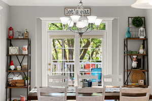 Entryway with a chandelier and ornamental molding