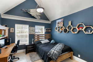 Bedroom featuring vaulted ceiling and an office area