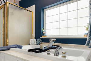 Bathroom featuring a garden tub and a shower stall