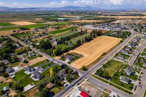 Aerial view of property and surrounding area with mountains and nearby suburban area