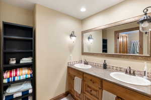 Full bathroom with double vanity and recessed lighting
