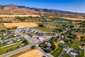 Aerial overview of property's location with nearby suburban area and a mountainous background