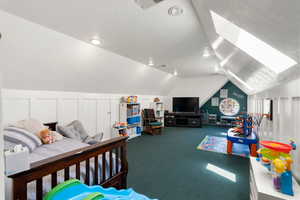 Carpeted bedroom with lofted ceiling and recessed lighting
