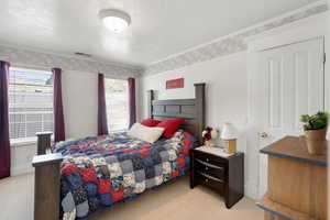 Bedroom featuring light colored carpet and a textured ceiling