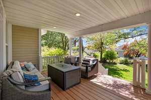 Wooden terrace featuring an outdoor living space and a yard