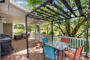 Wooden deck featuring outdoor dining space and grilling area