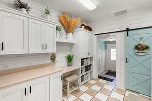 Mudroom with light tile patterned floors and wood walls