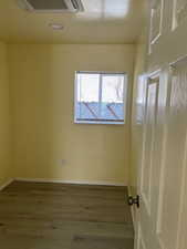 Empty room with hardwood / wood-style floors and recessed lighting
