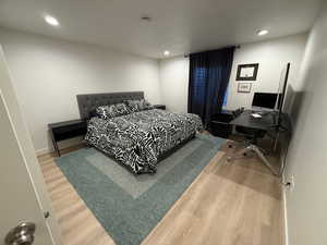Bedroom featuring light wood-style floors, an office area, and recessed lighting