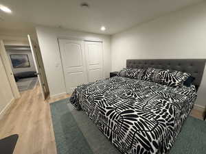 Bedroom featuring light wood-style flooring, recessed lighting, and a closet