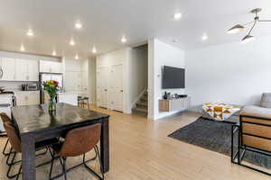 Dining space with a textured ceiling, light wood-type flooring, recessed lighting, and stairs