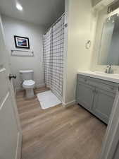 Bathroom featuring vanity, light wood-style floors, a shower stall, and recessed lighting