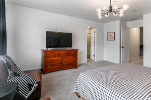 Bedroom featuring light carpet and a chandelier