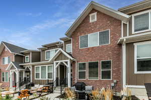 View of front of property with outdoor lounge area, board and batten siding, and brick siding
