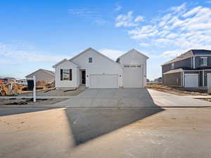 View of front of home with driveway, a garage, and board and batten siding