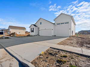 View of home's exterior with board and batten siding, concrete driveway, and a garage