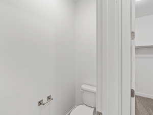 Bathroom featuring toilet and baseboards
