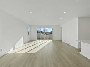 Empty room featuring light wood-style flooring and recessed lighting