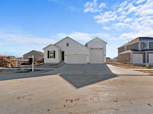 Modern inspired farmhouse featuring concrete driveway, an attached garage, and board and batten siding
