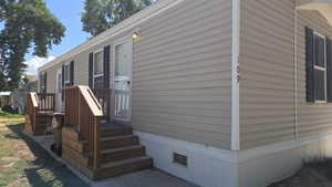 View of wooden terrace, front door and secondary entrance