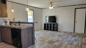 Kitchen featuring ornamental molding, black dishwasher, light wood style finished vinyl floors, a peninsula, and decorative light fixtures and living room
