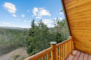 Balcony featuring a mountain view and a wooded view