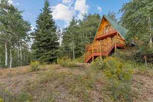 View of yard featuring a deck, stairs, and a forest view