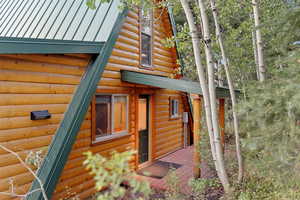 View of side of home with faux log siding and a deck