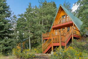 View of playground with stairs, a deck, and a view of trees