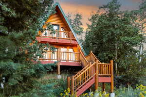 Rear view of house featuring a wooden deck and stairway