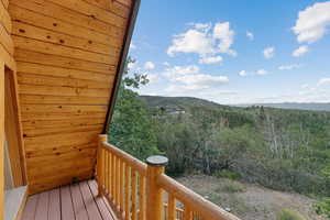 Deck with a mountain view and a view of trees
