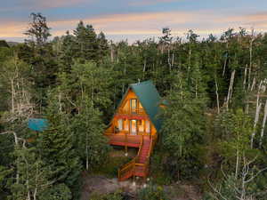 Rear view of house featuring stairway and a forest view