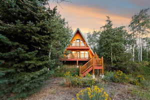 Rear view of property with a deck and stairs
