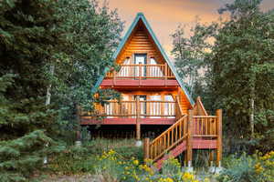 Rear view of property with a deck and stairway