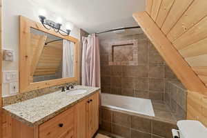 Bathroom with vanity and tiled shower / bath combo