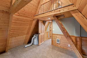 Bonus room featuring wood walls, carpet floors, and wooden ceiling