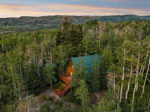 View of subject property featuring mountains and a heavily wooded area