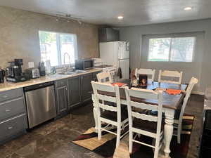 Kitchen featuring stainless steel appliances, plenty of natural light, and gray cabinets