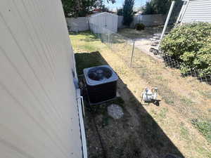 Exterior view of a fenced backyard and a central air condition unit