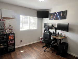 Office with baseboards and dark wood-type flooring