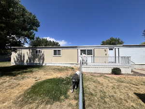 Manufactured / mobile home with a front yard and a deck