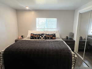 Bedroom with wood finished floors and a closet