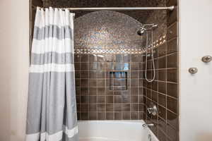 Bathroom with shower / bathtub combination with curtain