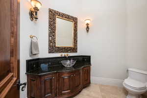 Half bathroom with vanity and light tile patterned flooring