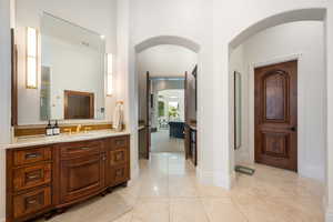 Bathroom with vanity, light tile patterned floors, and ornamental molding