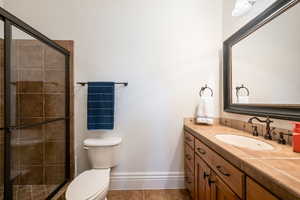 Bathroom with vanity, light tile patterned floors, and a stall shower